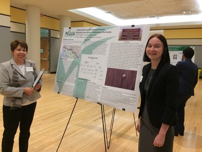 Associate dean, Michele Schweitz, poses alongside global affairs major, Kelsie Rohler, and her poster presentation