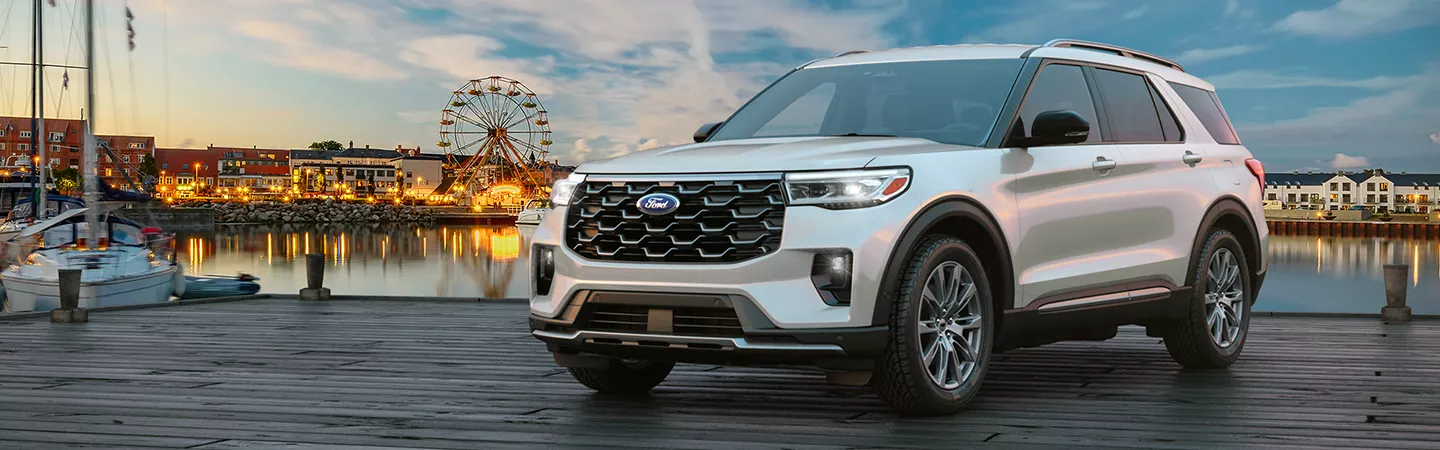 2026 Ford Explorer parked in front of a wharf with a sunset and ferris wheel in the background