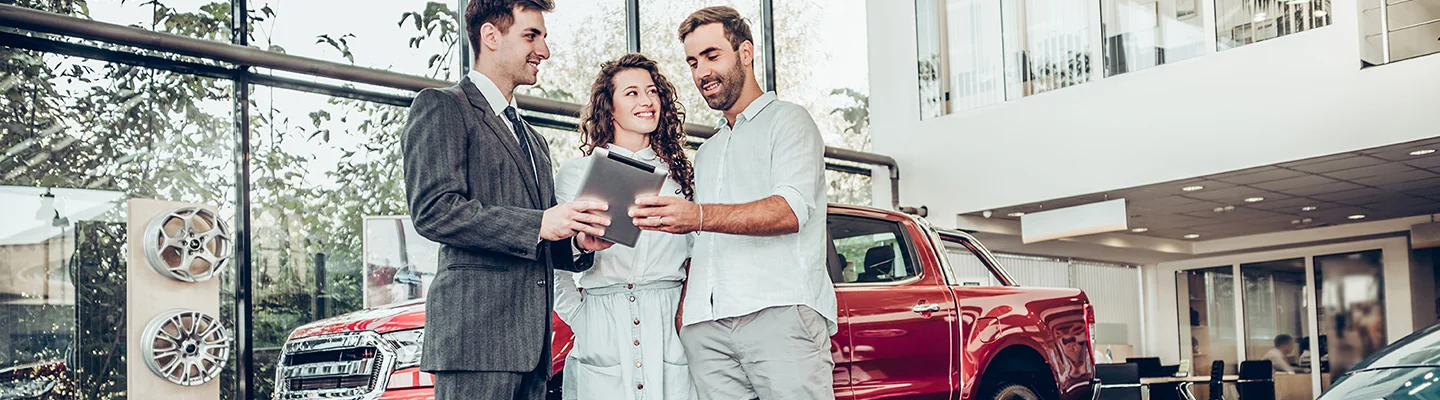 Sales person talking to customers about used car options