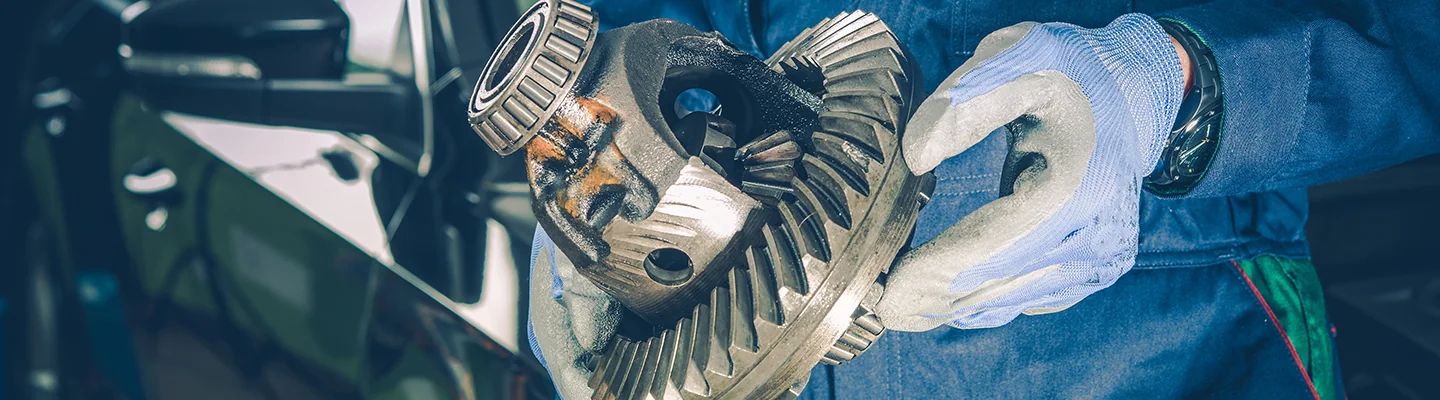 auto mechanic holding a part to transmission