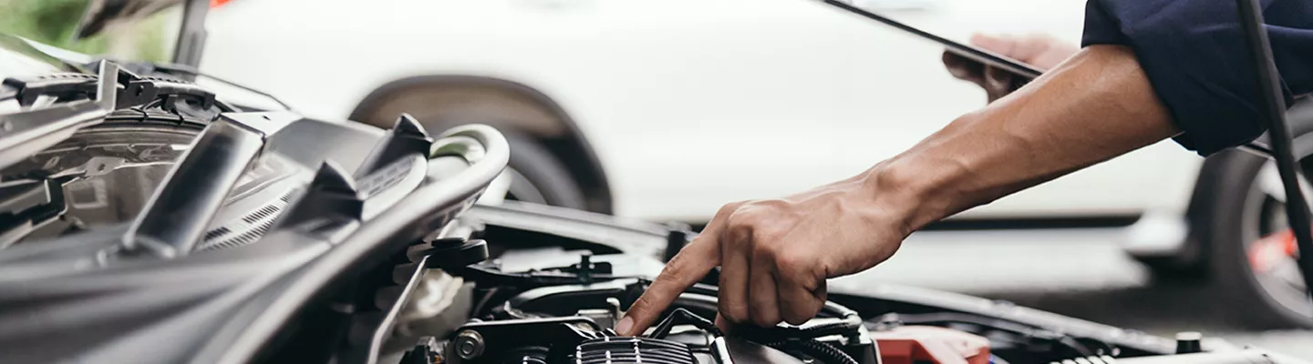 Service technician checking under the hood of a vehicle in Leesburg, FL