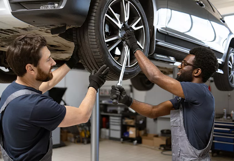 Service mechanic working on a car lifted in the air