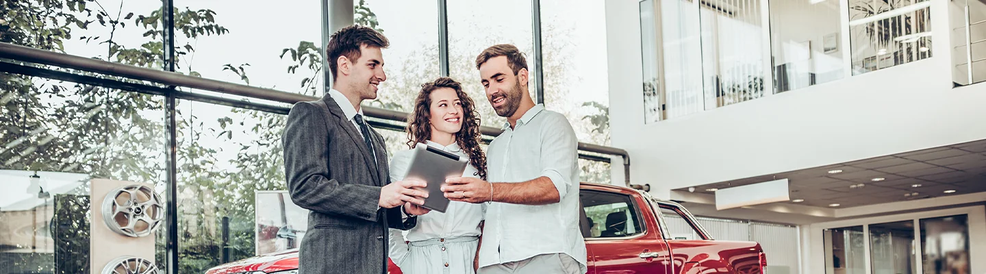 a couple speaks with car salesperson in showroom about the Flexible CDJR Financing Options