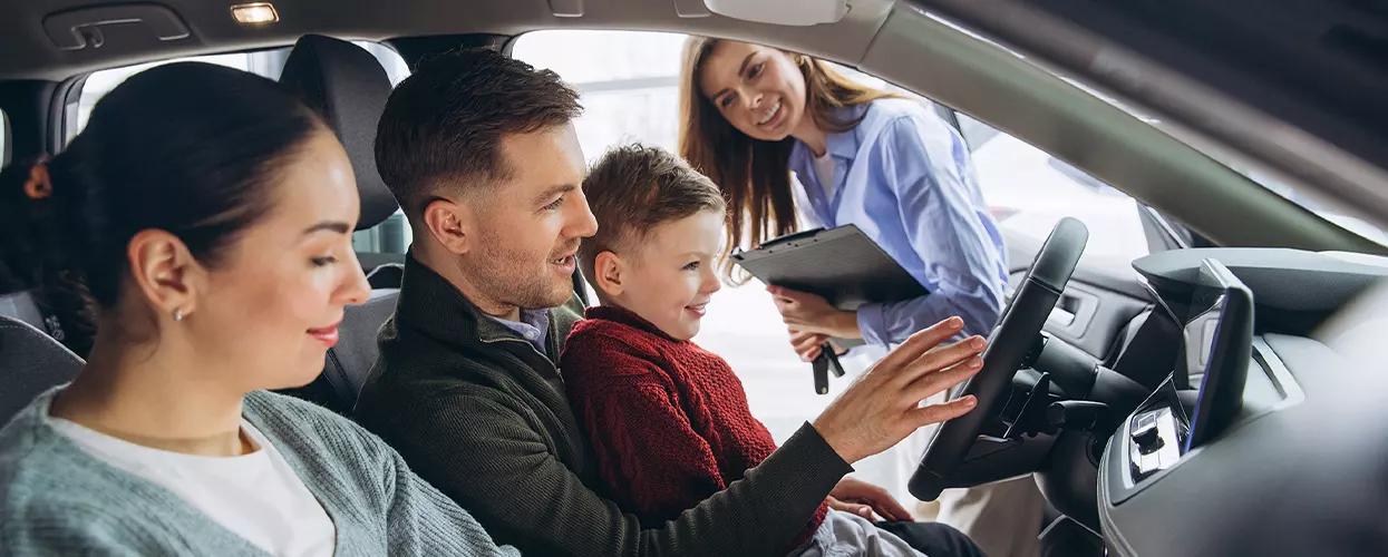 Family sitting in a new jaguar car at a car dealership