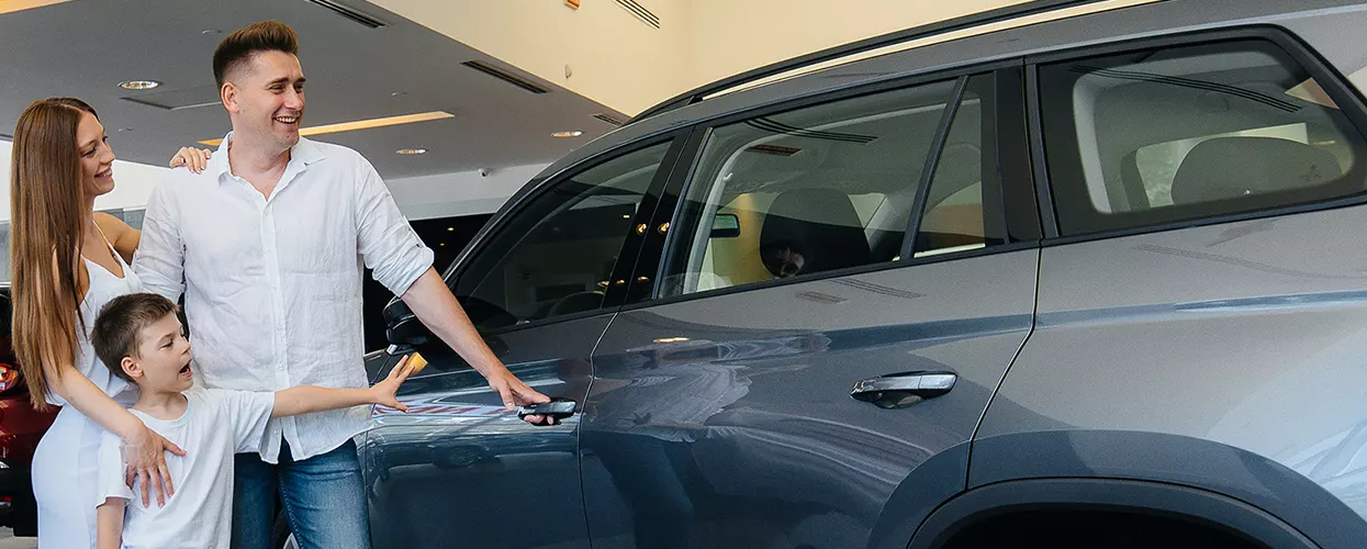 Family looking at a new vehicle at a car dealership