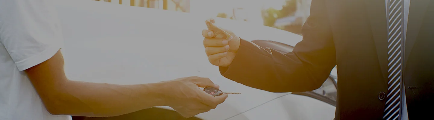 image of two arms and hands one with keys recieving the drop from another person