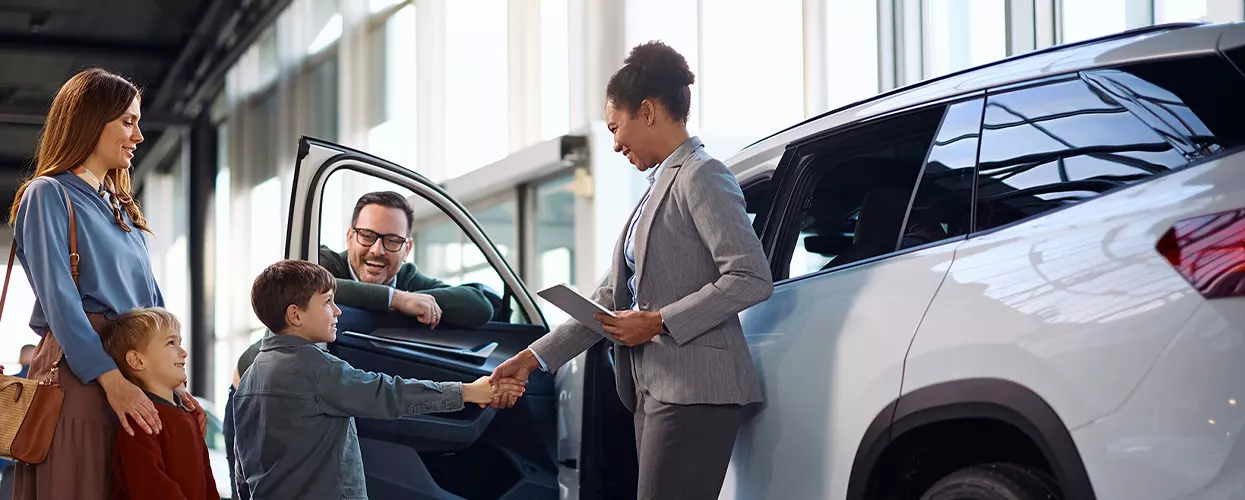 Car saleswoman talking to a family about a new vehicle