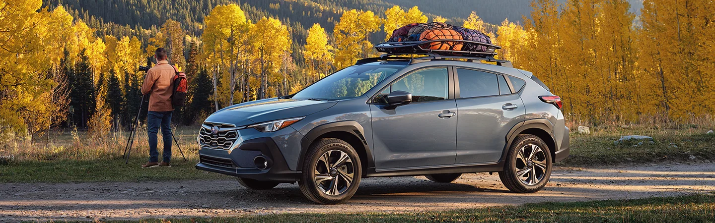 A parked 2025 Subaru Crosstrek with a forest in the background