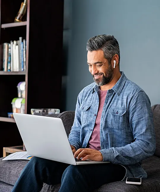 happy man smiling as looking at laptop