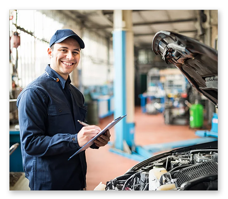 Mechanic in garage smiling at camera