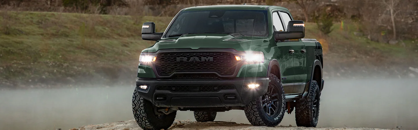 Front view of a parked green 2026 RAM 1500 on a dirt path