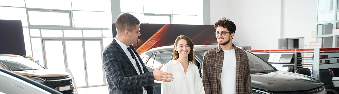 couple discussing car purchase with salesperson