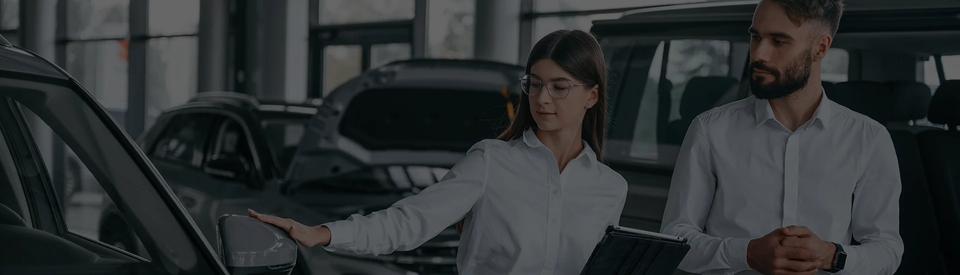 A black 2025 Volvo S90 Hybrid driving on a water side road