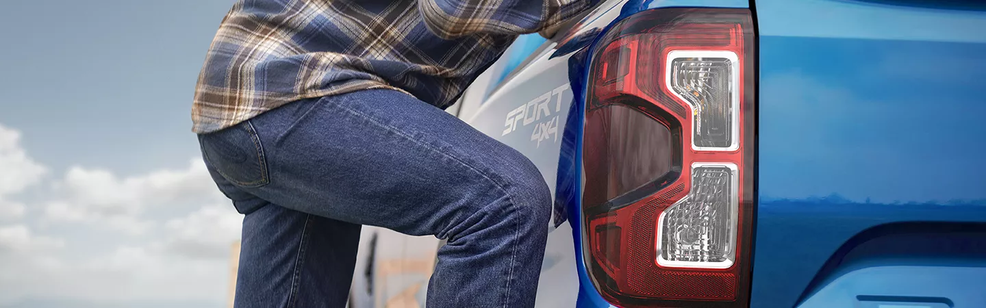 Person stepping up onto the tailgate of a 2025 Ford Ranger