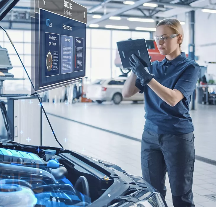 mechanic in the shop room running a diagnosis of a vehicle on the computer