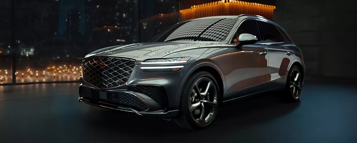 Genesis GV70 parked in a dark room with lights behind it