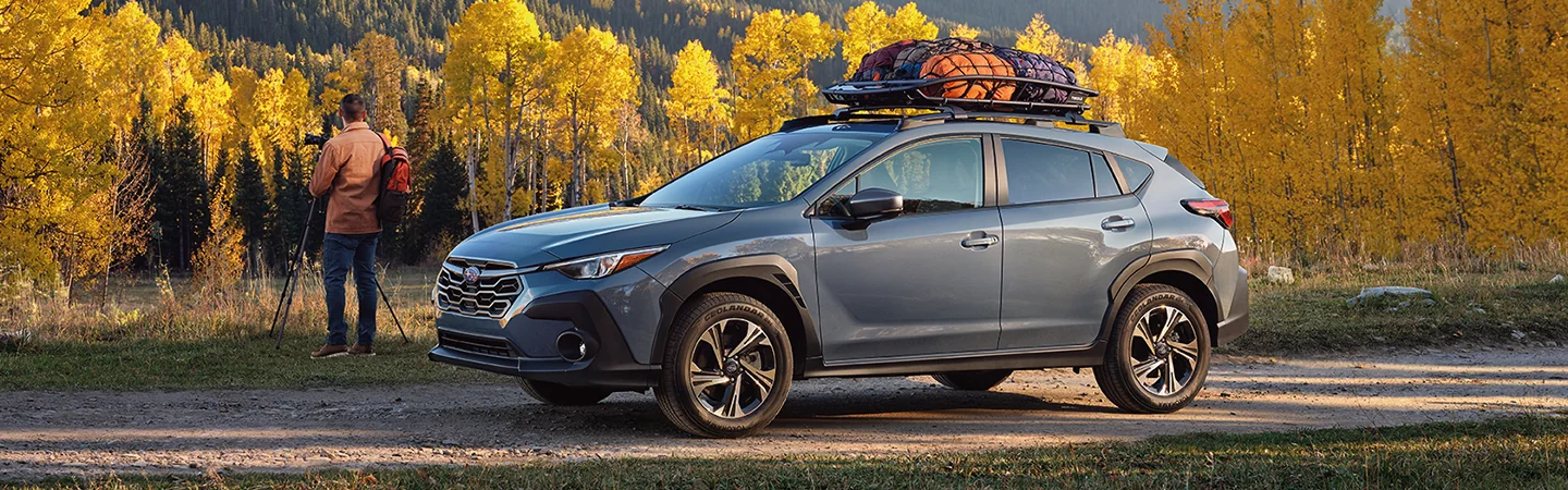 2025 Subaru Crosstrek Man standing on blue color car