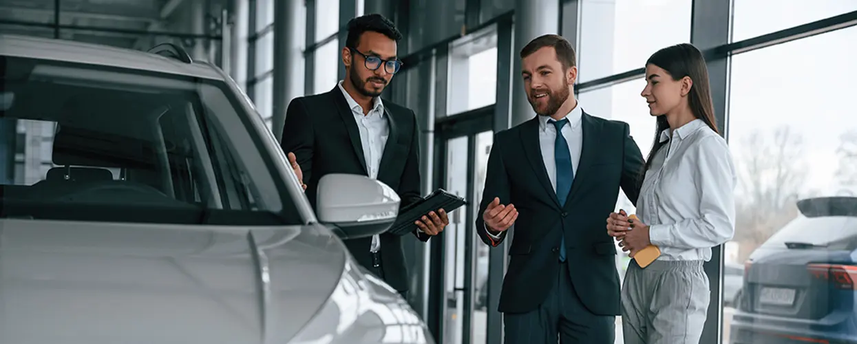 Rep showing a customer a clipboard with new car information