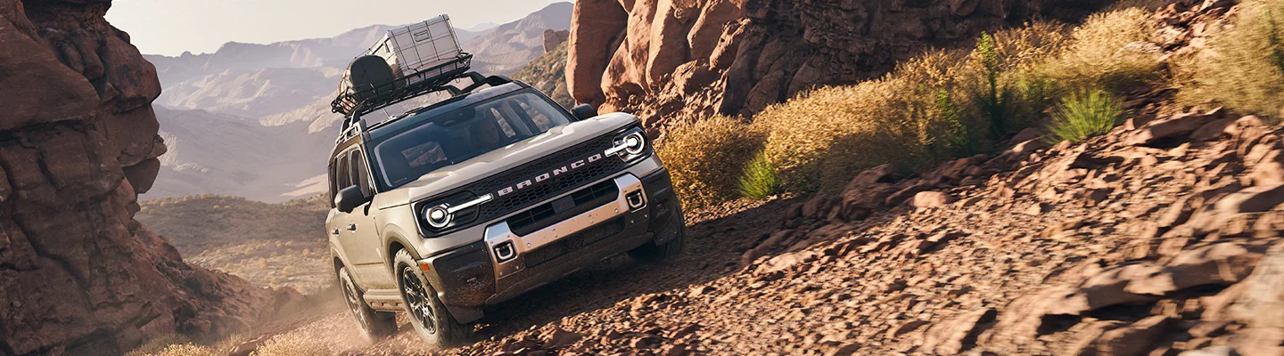 2025 Ford Bronco Raptor climbing a dirt hill offroad