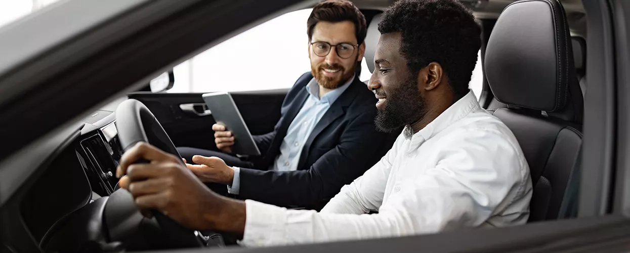 Car salesman showing a customer the interior of a vehicle