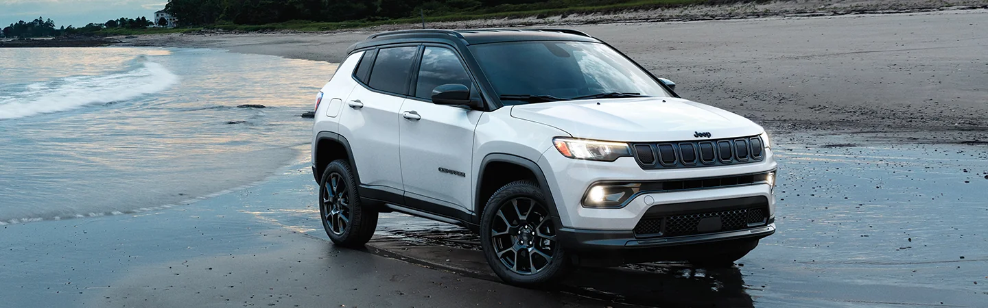 2025 Jeep Grand Cherokee white coloured car is parked on the beach side