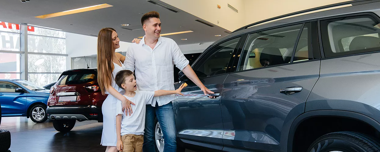 Family looking at a new vehicle at a car dealership