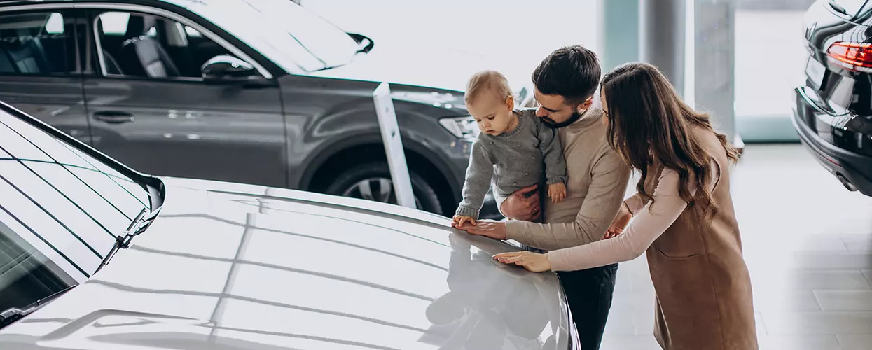 Family looking at a new car in a car dealership