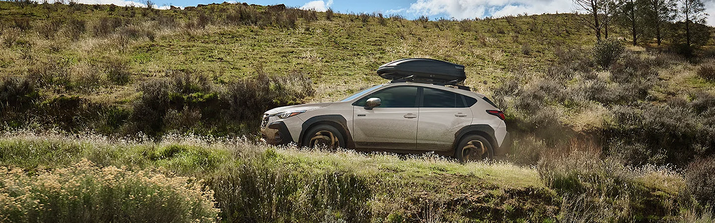 2026 Subaru Crosstrek Sport Hybrid offroad with a storage container on top