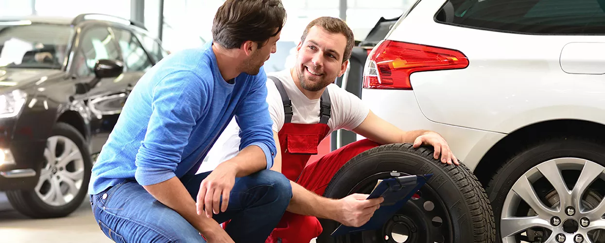 Service mechanic changing tires on a vehicle