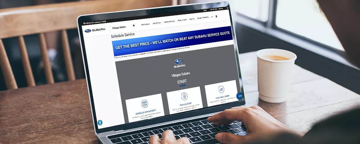 Customer using their laptop to view the Villages Subaru website