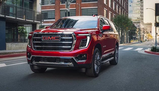 Front view of a red GMC SUV drivng in downtown St. Petersburg, FL
