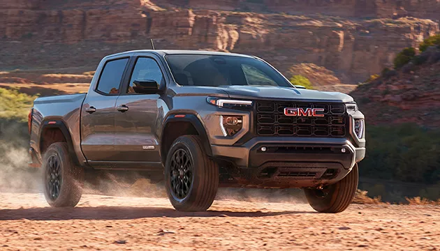 Side view of a gray parked GMC truck in the desert