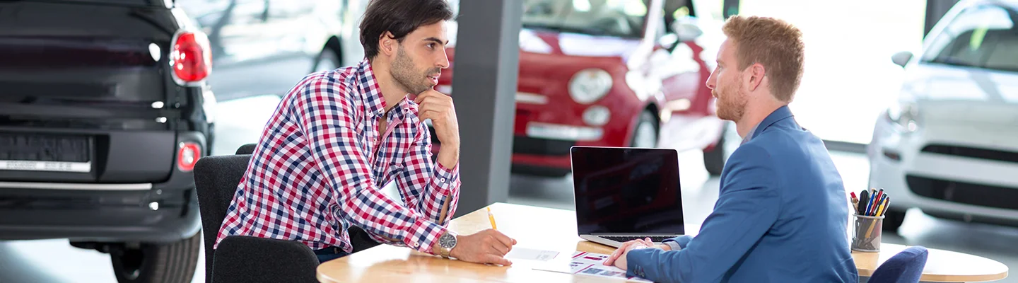two people discussing car purchase in dealership