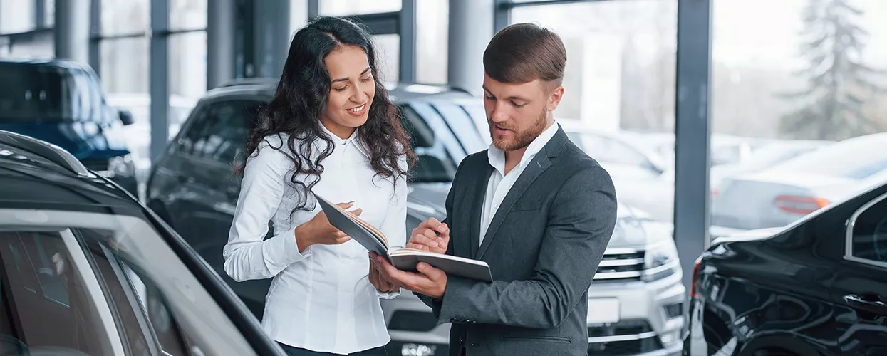 Car salesman talking to a customer about a new vehicle