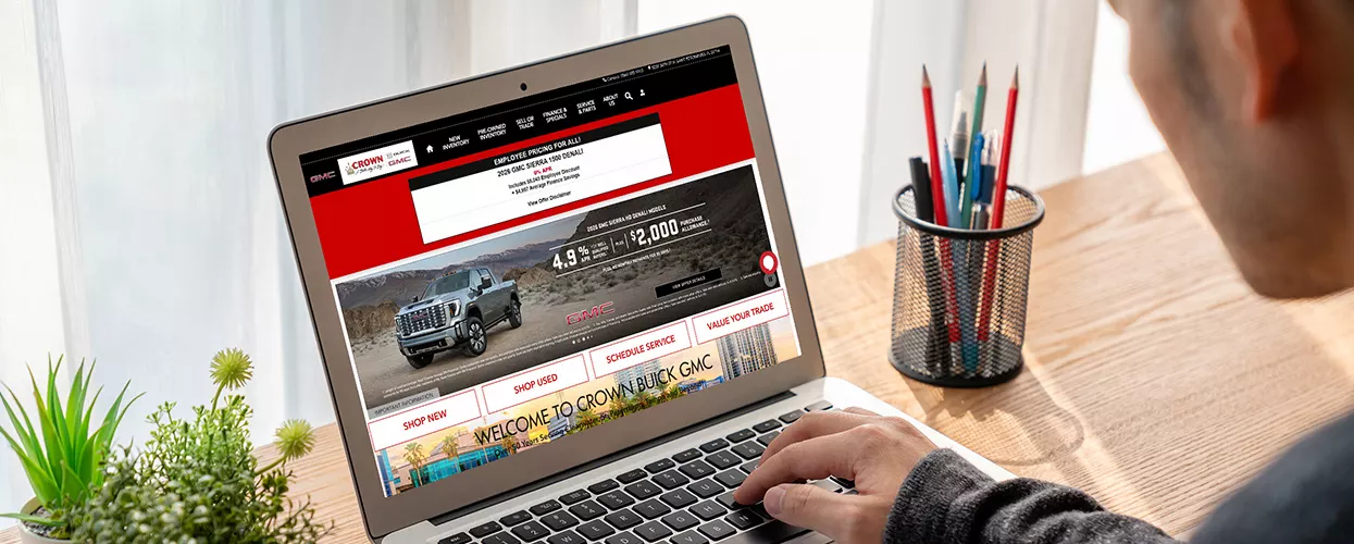 Customer using their laptop to view the Crown GMC Buick website from home