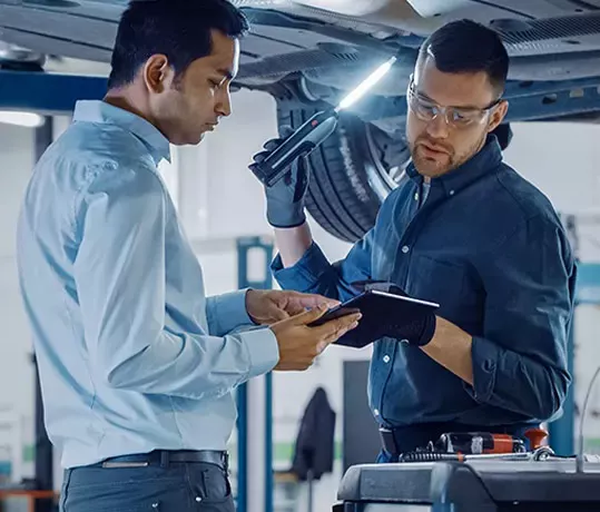 2 Technician going over servicing of a vehicle