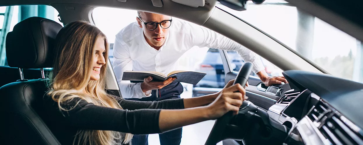 Car salesman showing a customer the interior of the vehicle