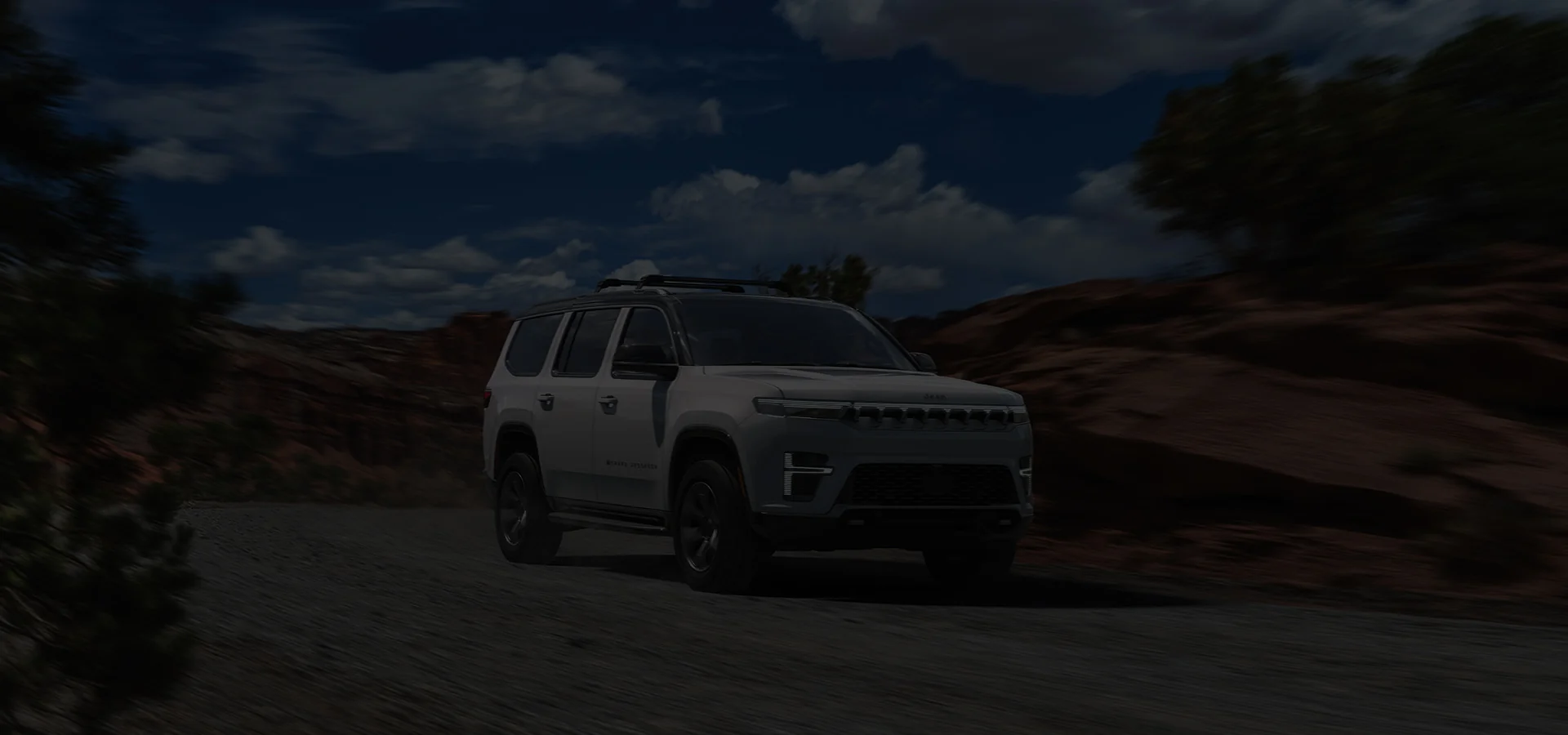 A white Jeep driving in the desert