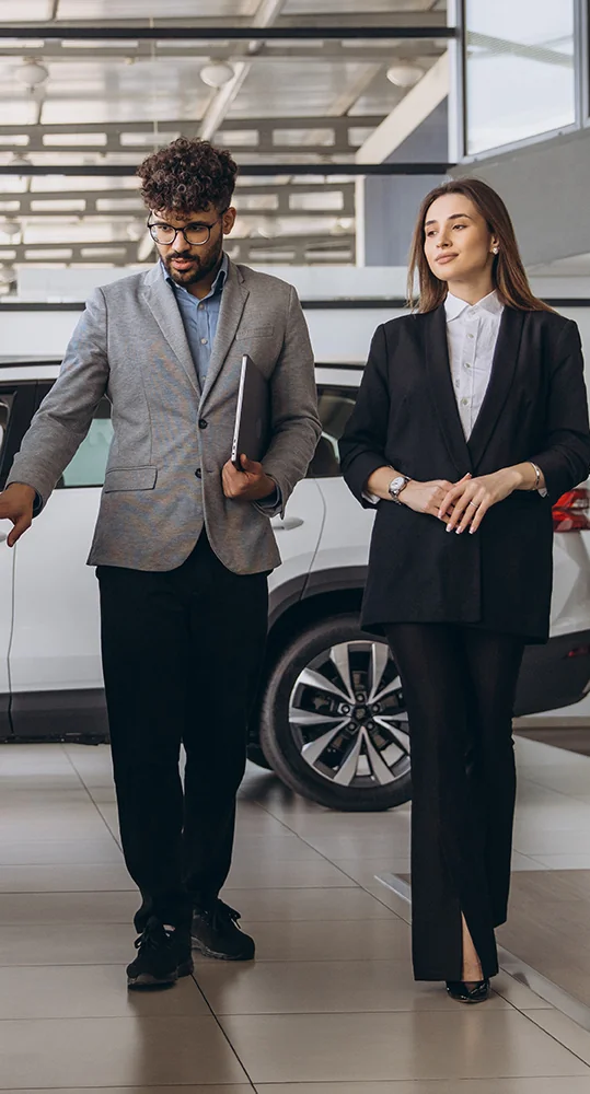 Sales person showing a customer cars in the show room