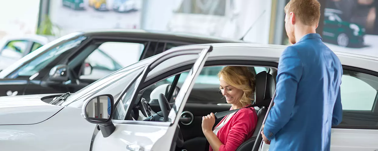 Car salesman showing a customer the interior of a vehicle