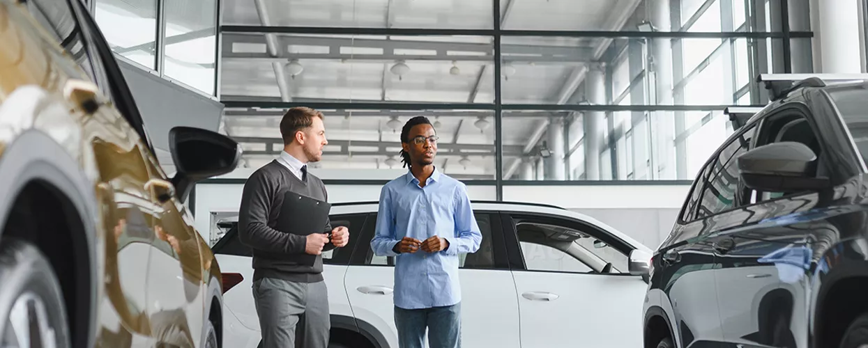 Car salesman showing a customer a new vehicle at a Mercedes-Benz dealership