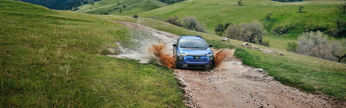 2026 Subaru Trailseeker Premium going through a muddy puble off road spitting up wet mud