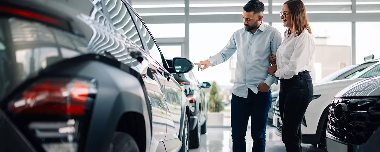 Couple walking through a car dealership looking at new vehicles