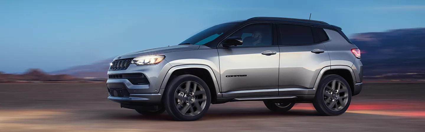 2025 Jeep Compass driving in the desert with mountains in the background