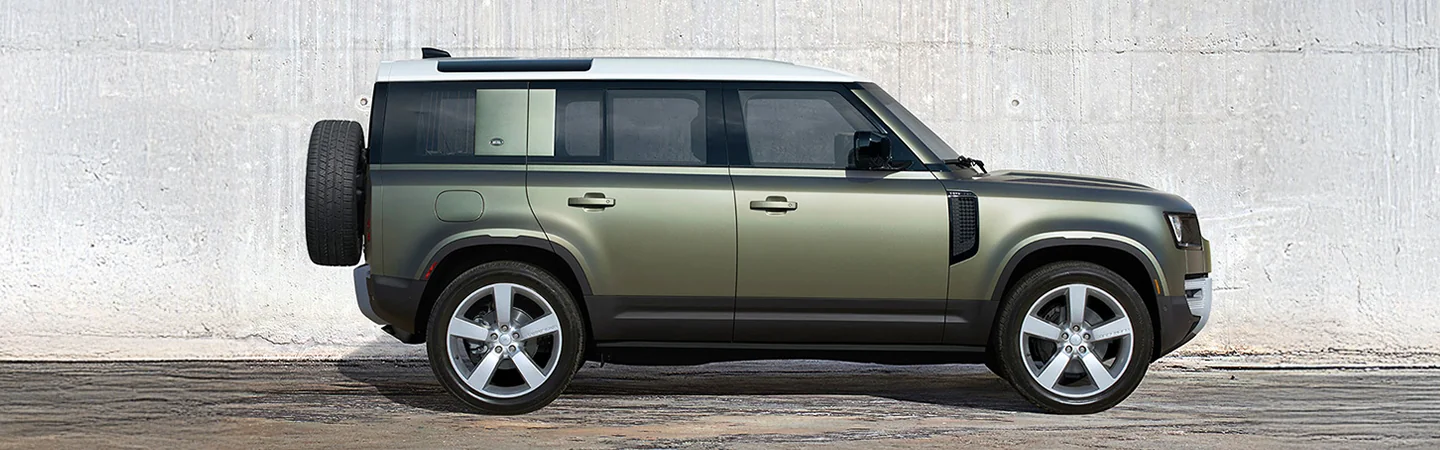 Side view of a parked green 2025 Defender 110