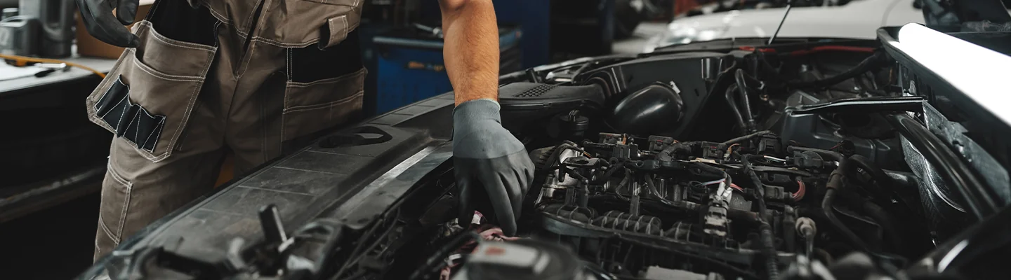 auto mechanic working on car engine