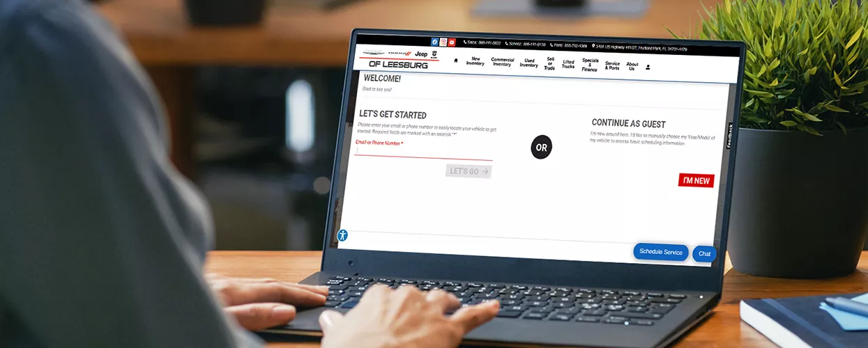 Person using their laptop to look at the CDJR of Leesburg website