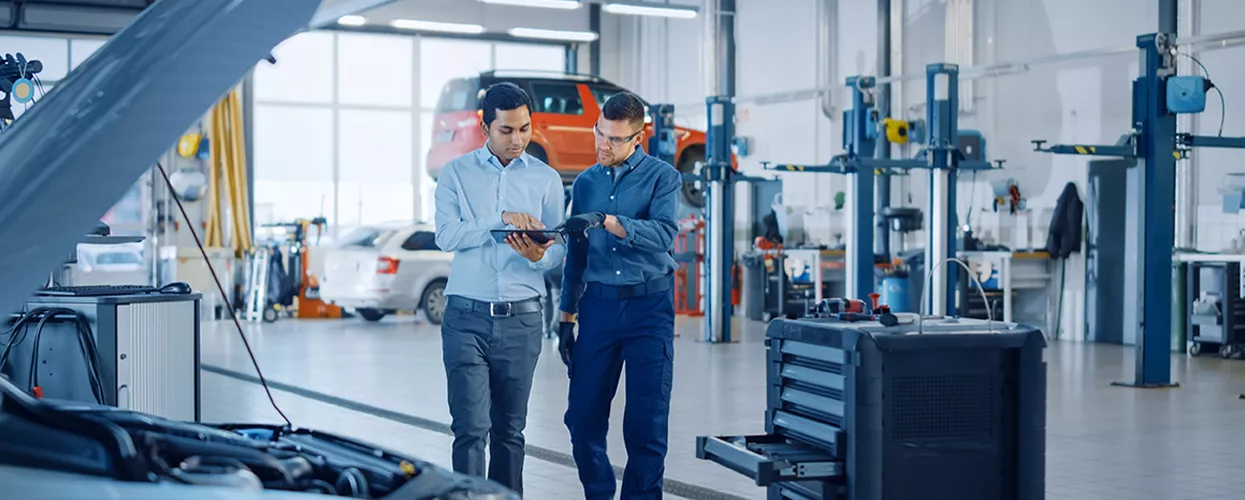 Two service mechanics looking at a tablet