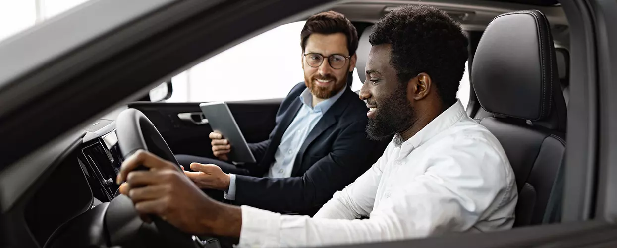 Car salesman shwoing a customer the interior of a vehicle