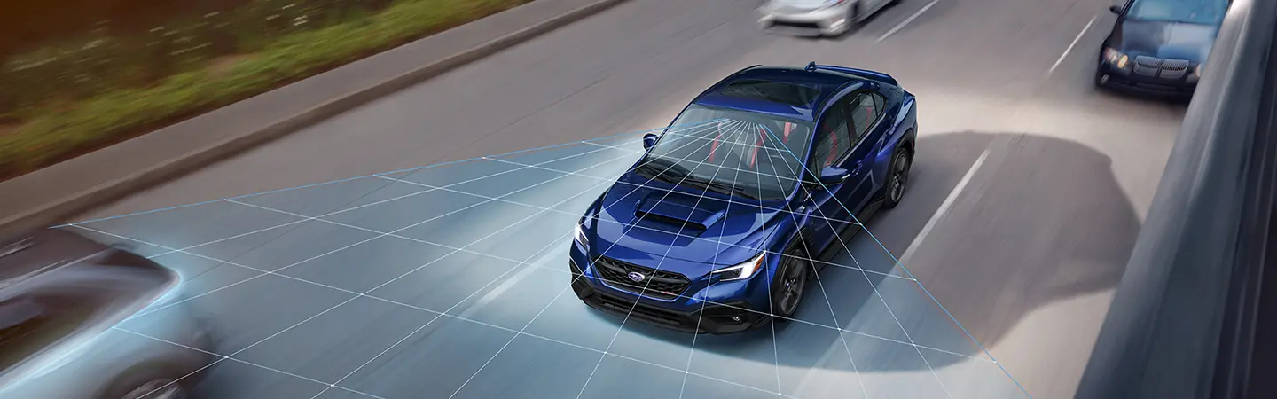 Front view of a blue 2025 Subaru WRX driving on a freeway showing from senors